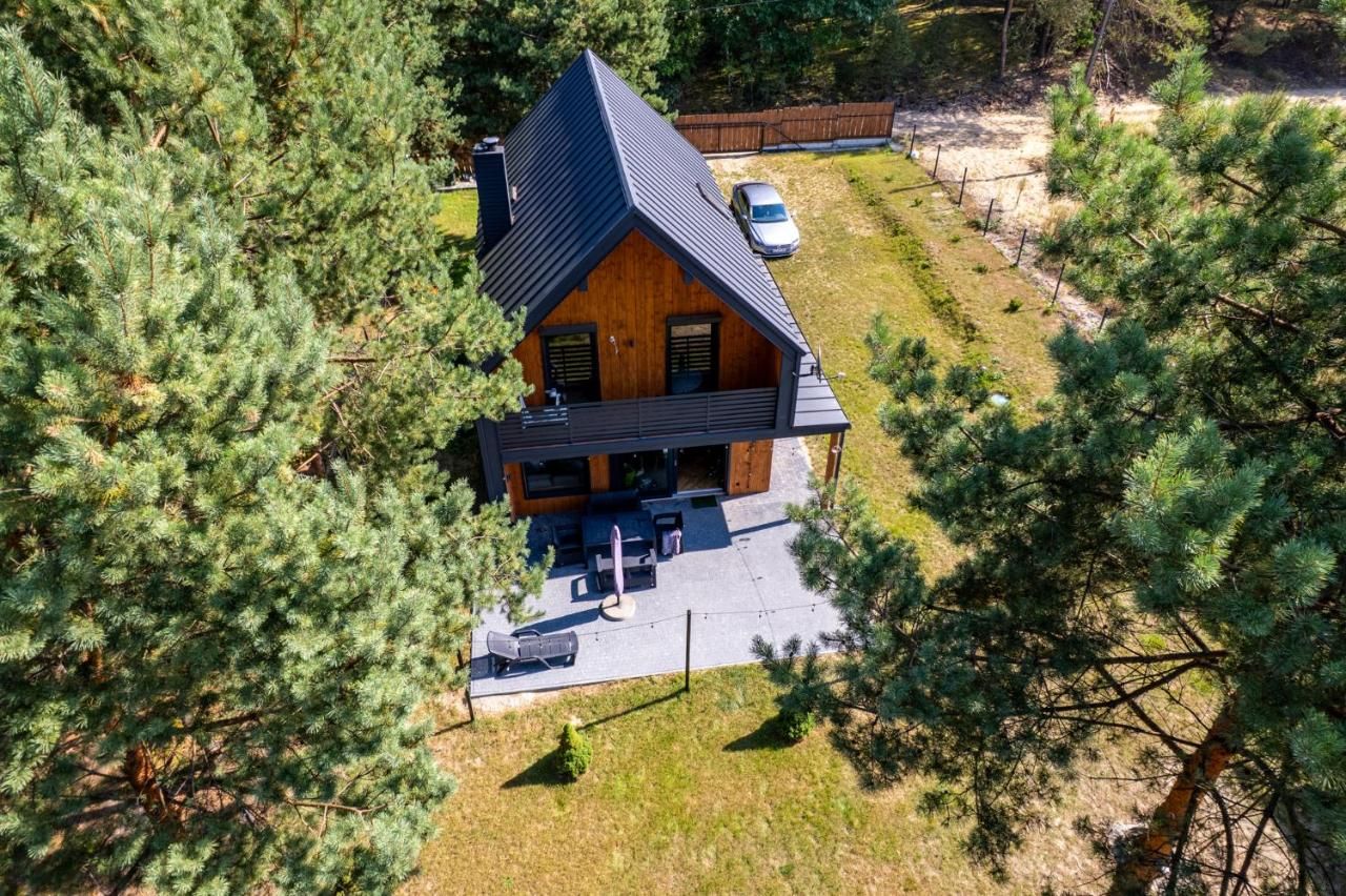 Widok z góry na drewnianą stodołę otoczoną drzewami